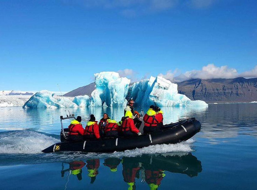 People on a boat exploring the glacier lagoon during a Zodiac tour in Iceland in July.