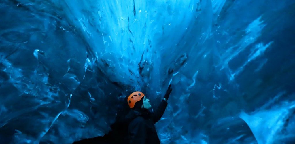 Man exploring a Blue Ice Cave in Iceland.