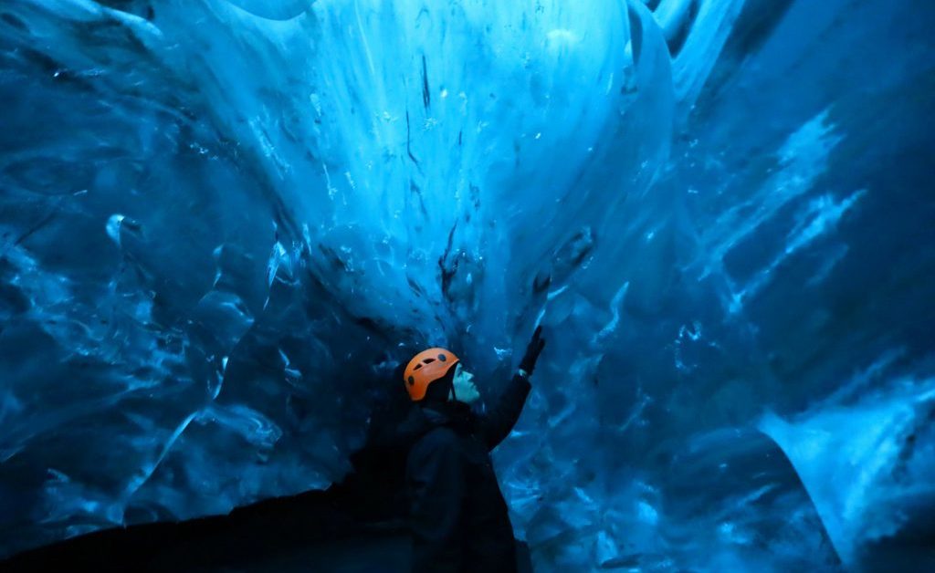 Man exploring a Blue Ice Cave in Iceland.