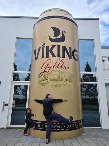 Hugging a giant beer can.