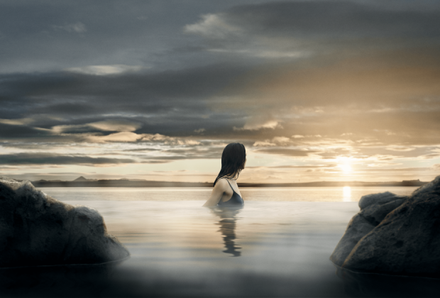 Woman enjoying the view ofer the ocean from the infinity pool at Sky Lagoon.