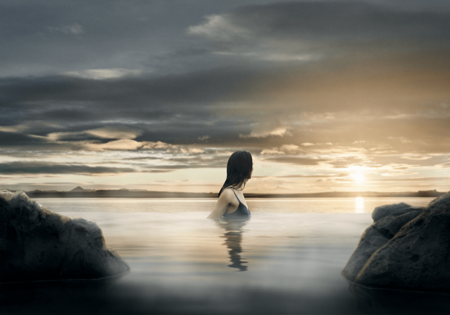 Woman enjoying the view ofer the ocean from the infinity pool at Sky Lagoon.