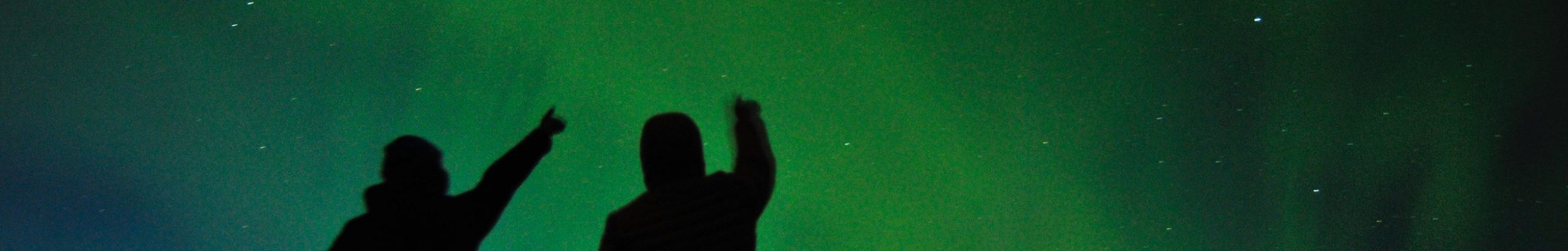 People watching the Northern Lights dancing in the sky. Northern Lights guided tour.