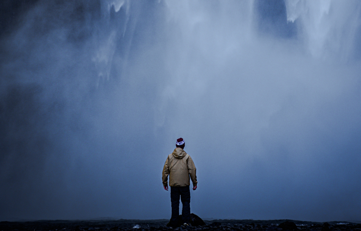 Man in front of the waterfall.